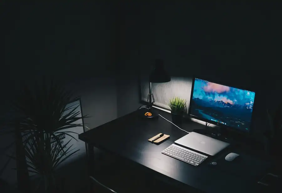 Mesa de estudo à noite, com um monitor aceso